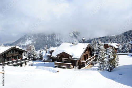 Beautiful wooden  chalets in winter covered with snow