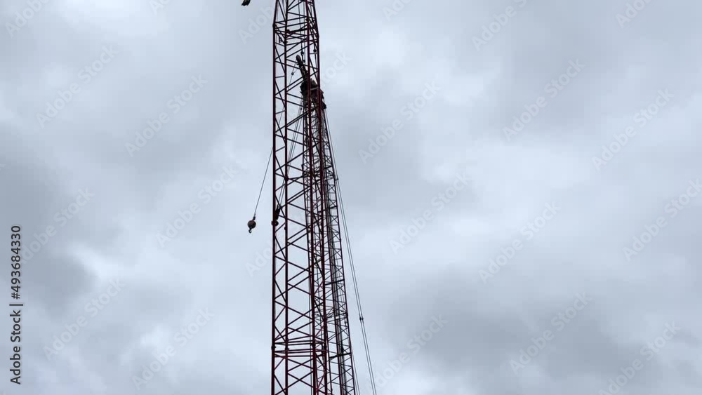 Tilt up of a Silhouette of a crane boom and fast moving storm clouds rainy day Tilt up of a Silhouette of a crane boom and fast moving storm clouds rainy day