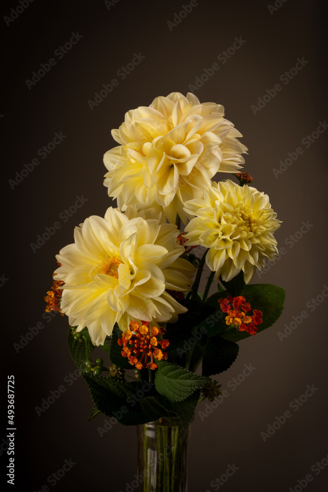 A stunning studio set with yellow Dahlia flowers with small orange flowers to fill taken vintage type lighting perfect for valentines or table to setting or just to brighten a room