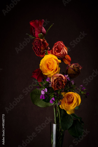 A warm lit vintage studio set with a still life of a bouquet of flowers alive and dead with soft lighting perfect for wedding or valentines or anniversary showing love and compassion for your spouse 