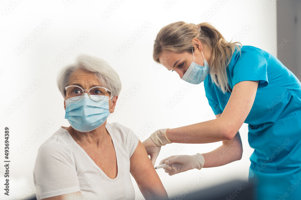 Responsible caucasian senior lady getting a vaccine jab. . High quality photo
