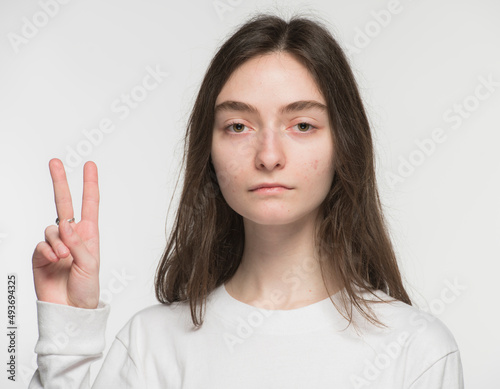 close-up portrait of a young Ukrainian girl who shows the number with her hands on a white background 