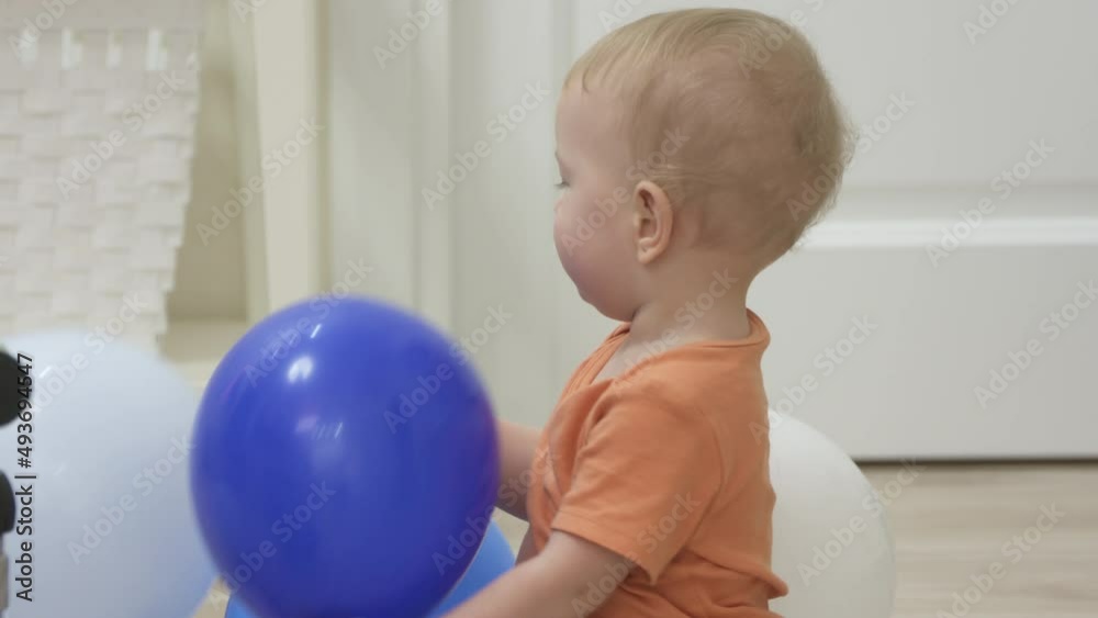 Kid celebrating his first birthday received a balance bike as a gift, baby boy on baby balance bike for 1 year old kids riding toy. High quality 4k footage