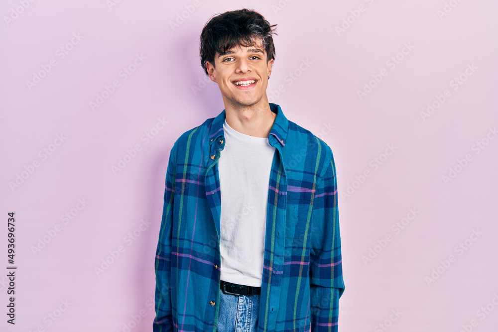 Handsome hipster young man wearing casual white t shirt and vintage shirt with a happy and cool smile on face. lucky person. Handsome hipster young man wearing casual white t shirt and vintage shirt with a happy and cool smile on face. lucky person.