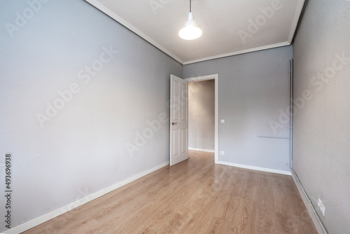Empty room with oak wood floor, gray walls and white woodwork