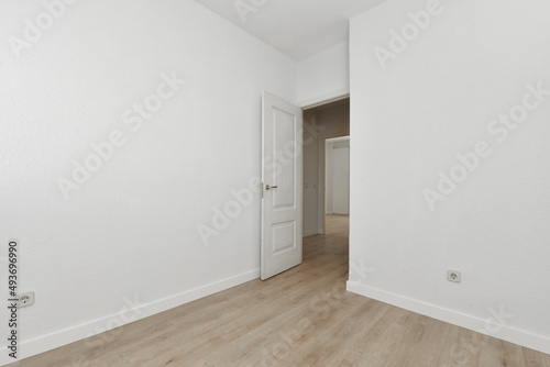 empty living room with freshly painted walls and light oak flooring and white wooden door