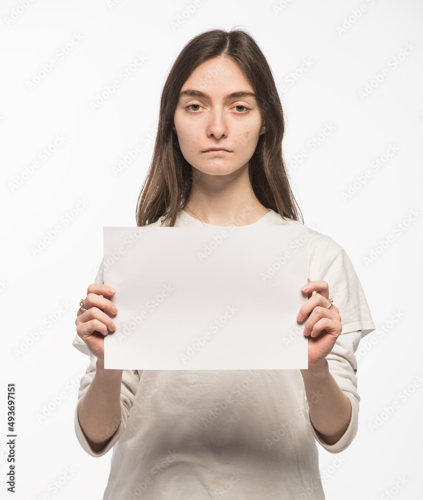 portrait of a sad but self-confident Ukrainian girl with a blank sheet of paper in her hands on a white background portrait of a sad but self-confident Ukrainian girl with a blank sheet of paper in her hands on a white background