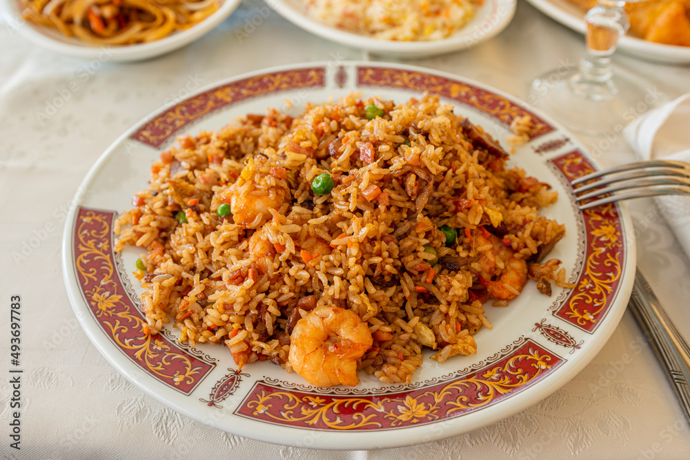 Chinese rice with prawns, vegetables and soy sauce on a decorated plate