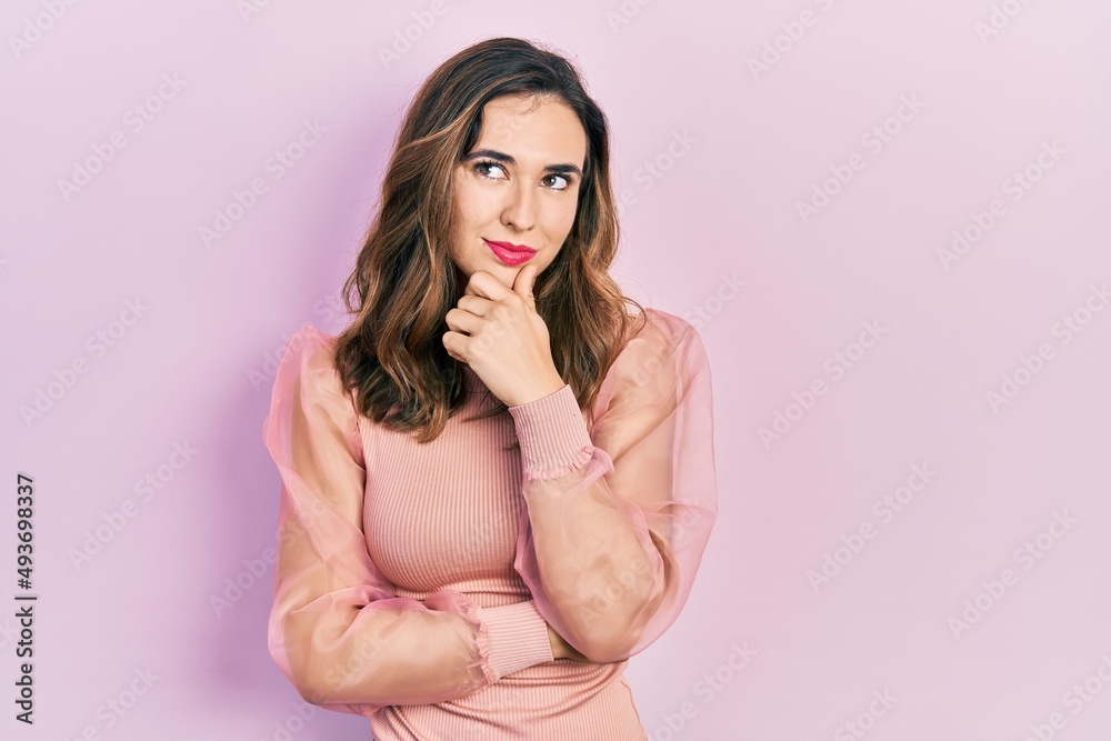 Young hispanic girl wearing casual clothes with hand on chin thinking about question, pensive expression. smiling with thoughtful face. doubt concept. Young hispanic girl wearing casual clothes with hand on chin thinking about question, pensive expression. smiling with thoughtful face. doubt concept.