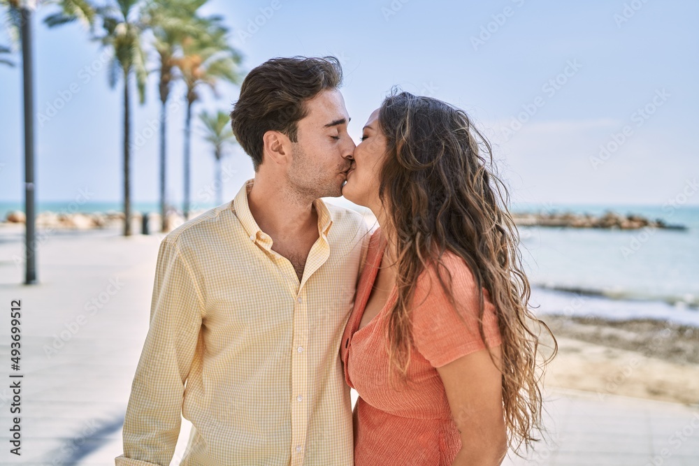 Man and woman couple hugging and kissing each other at seaside Man and woman couple hugging and kissing each other at seaside