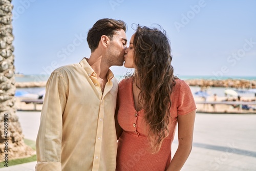 Man and woman couple hugging and kissing each other at seaside