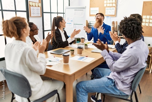 Group of business workers smiling and clapping to partner at the office.