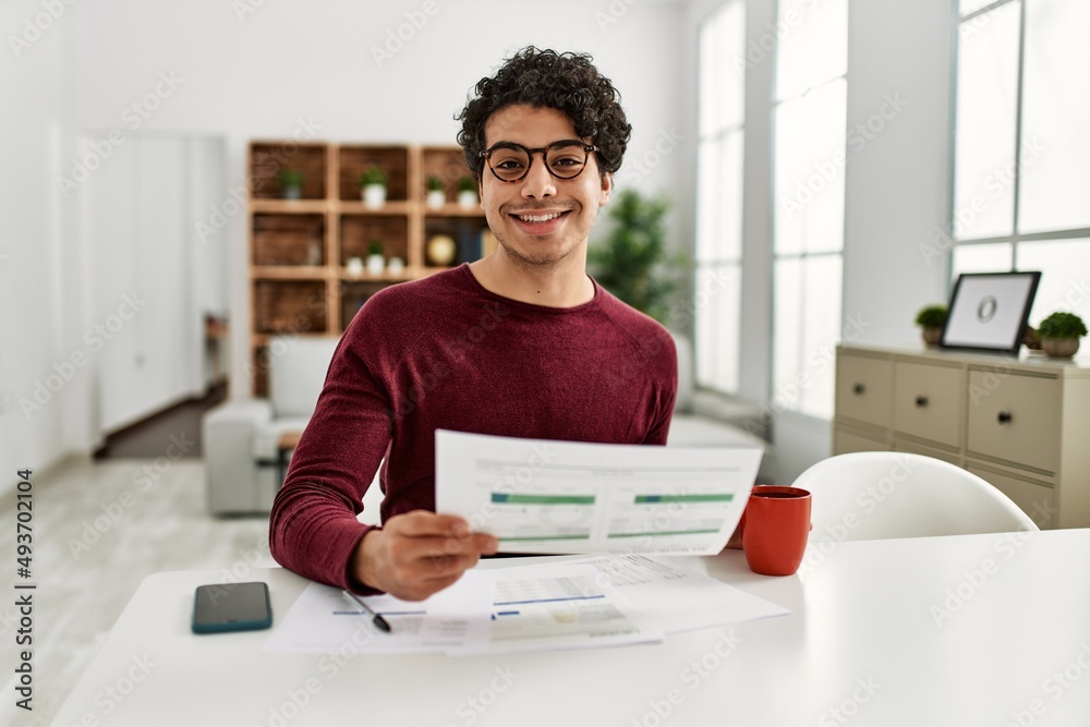 Young hispanic man working at home.