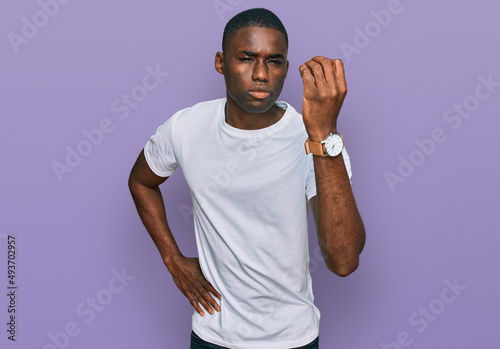 Young african american man wearing casual white t shirt doing italian gesture with hand and fingers confident expression