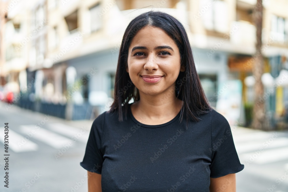 Young latin woman smiling confident standing at street