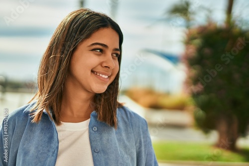 Young latin girl smiling happy standing at the city.