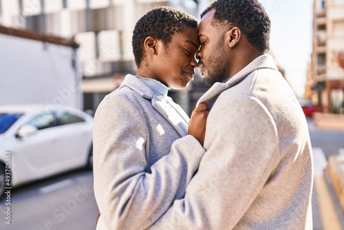 Man and woman couple hugging each other and kissing at street