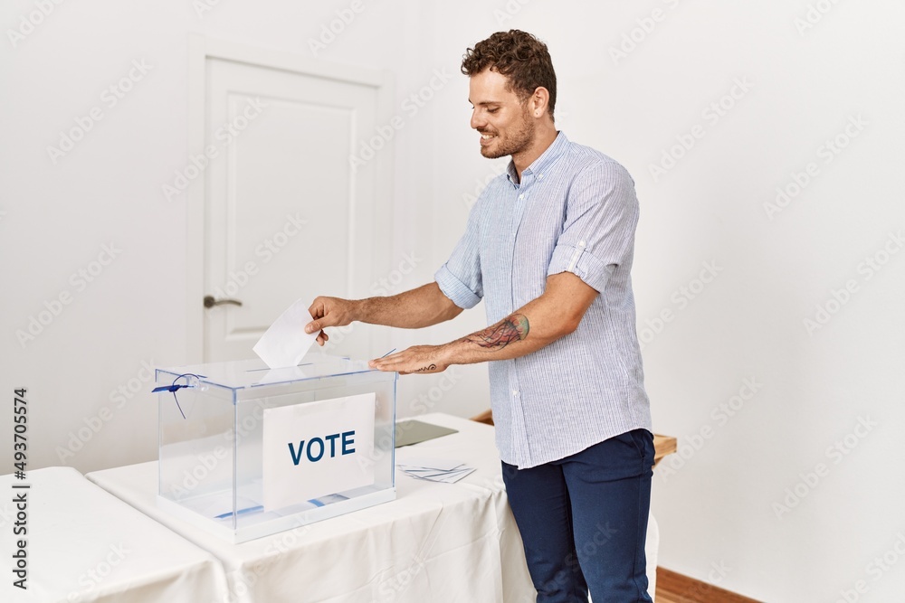 Young hispanic man smiling confident voting at electoral college