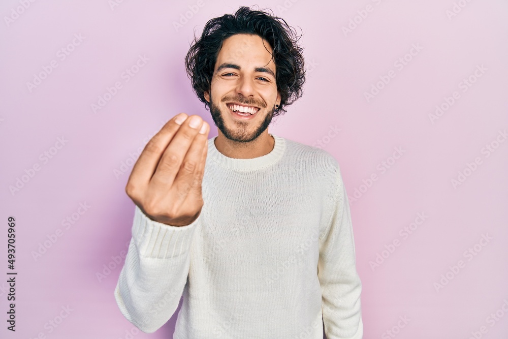 Fototapeta premium Handsome hispanic man wearing casual white sweater doing italian gesture with hand and fingers confident expression