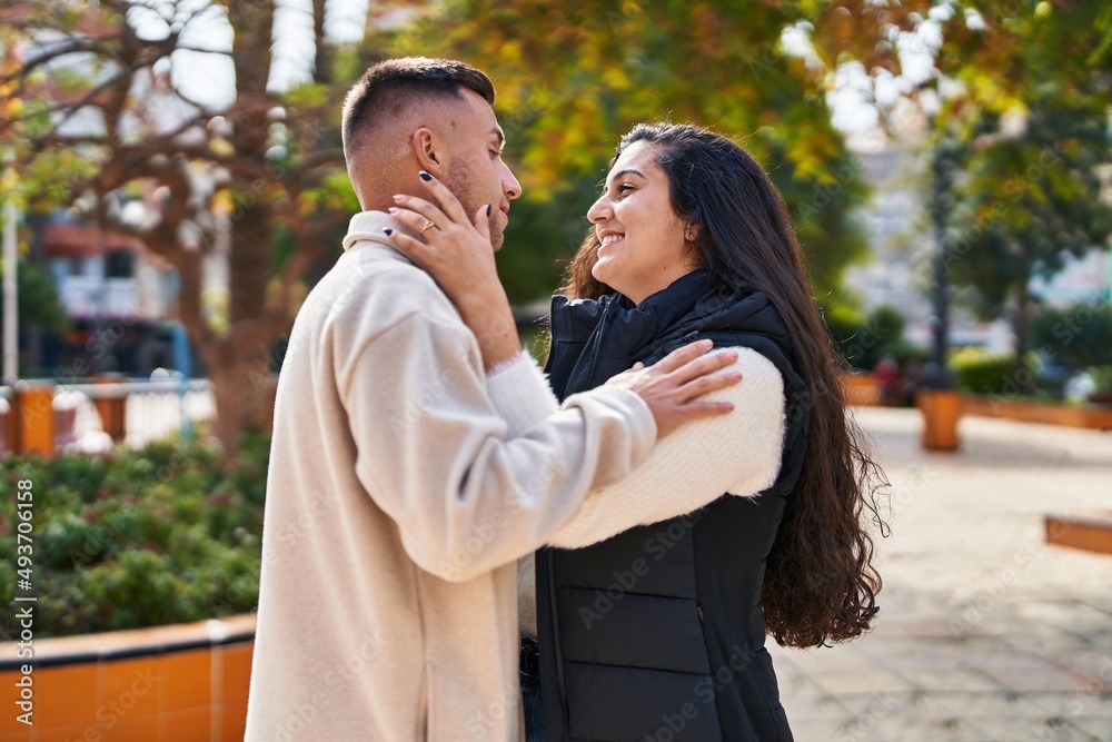 Obraz premium Man and woman couple hugging each other standing at park