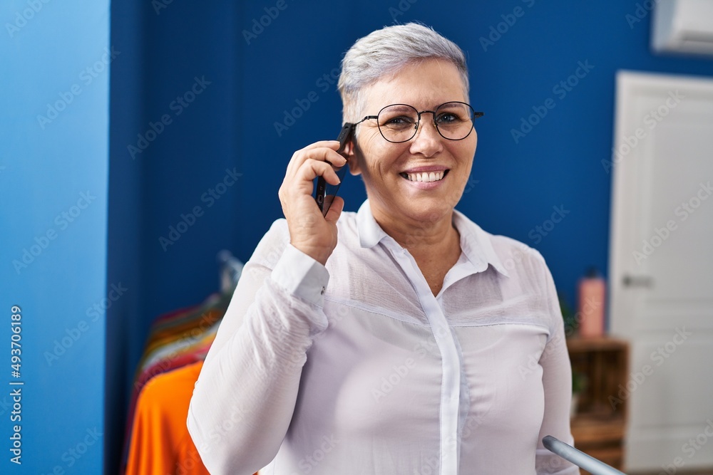 Middle age woman smiling confident talking on the smartphone at laundry room Middle age woman smiling confident talking on the smartphone at laundry room