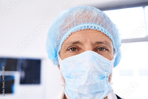 Hes ready for surgery. Shot of a mature male surgeoun wearing a surgical mask and cap.