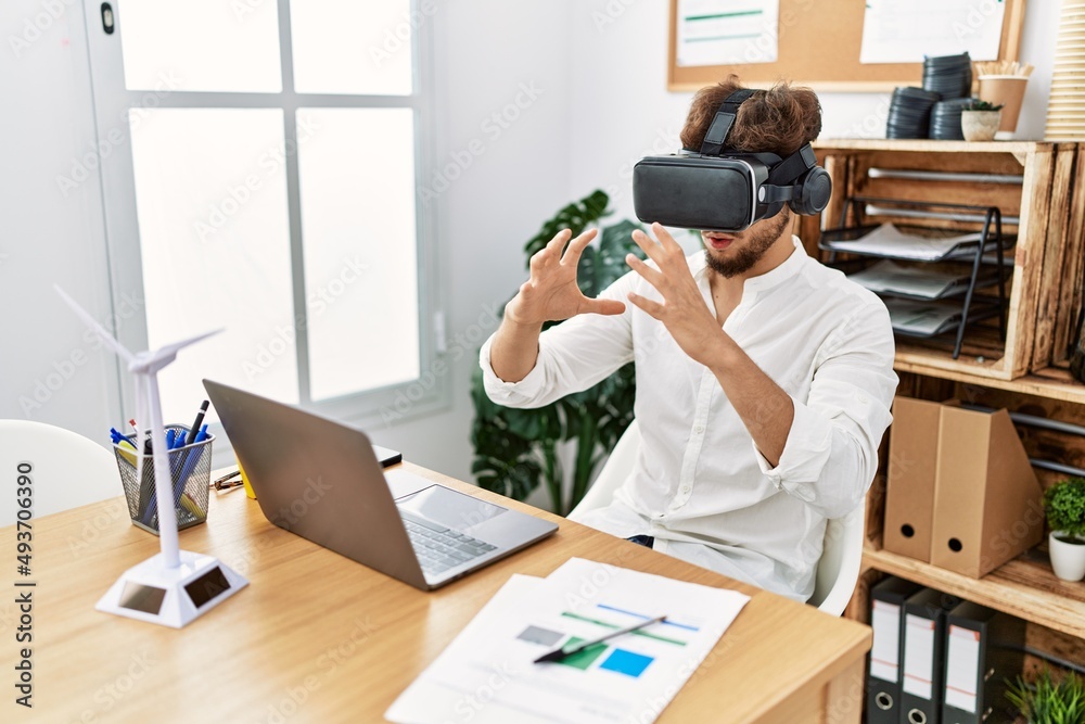 Young arab man using vr goggles working at office Young arab man using vr goggles working at office