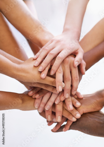 Showing solidarity. Shot of a group of people putting their hands together.