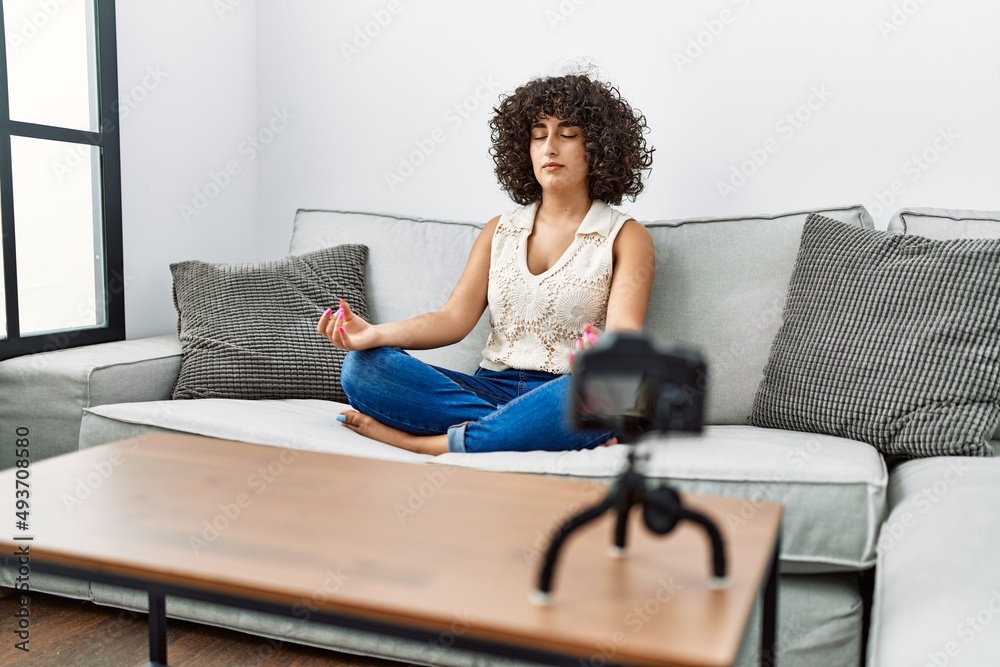 Young middle east woman doing online yoga class at home Young middle east woman doing online yoga class at home