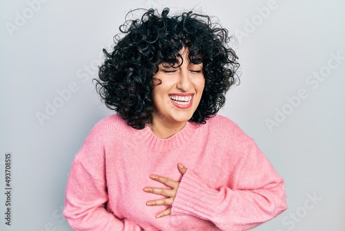 Young middle east woman wearing casual clothes smiling and laughing hard out loud because funny crazy joke with hands on body.