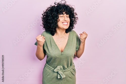 Young middle east woman wearing casual clothes excited for success with arms raised and eyes closed celebrating victory smiling. winner concept.