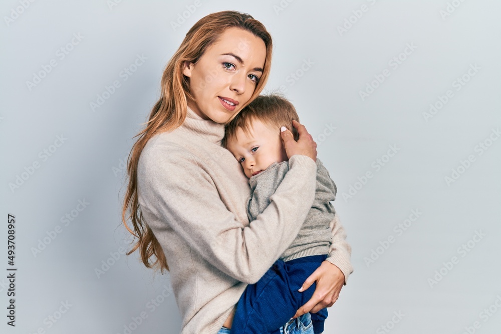 Young caucasian woman holding and hugging her son with love. Family of two bonding together. Mother holding infant toddler Young caucasian woman holding and hugging her son with love. Family of two bonding together. Mother holding infant toddler