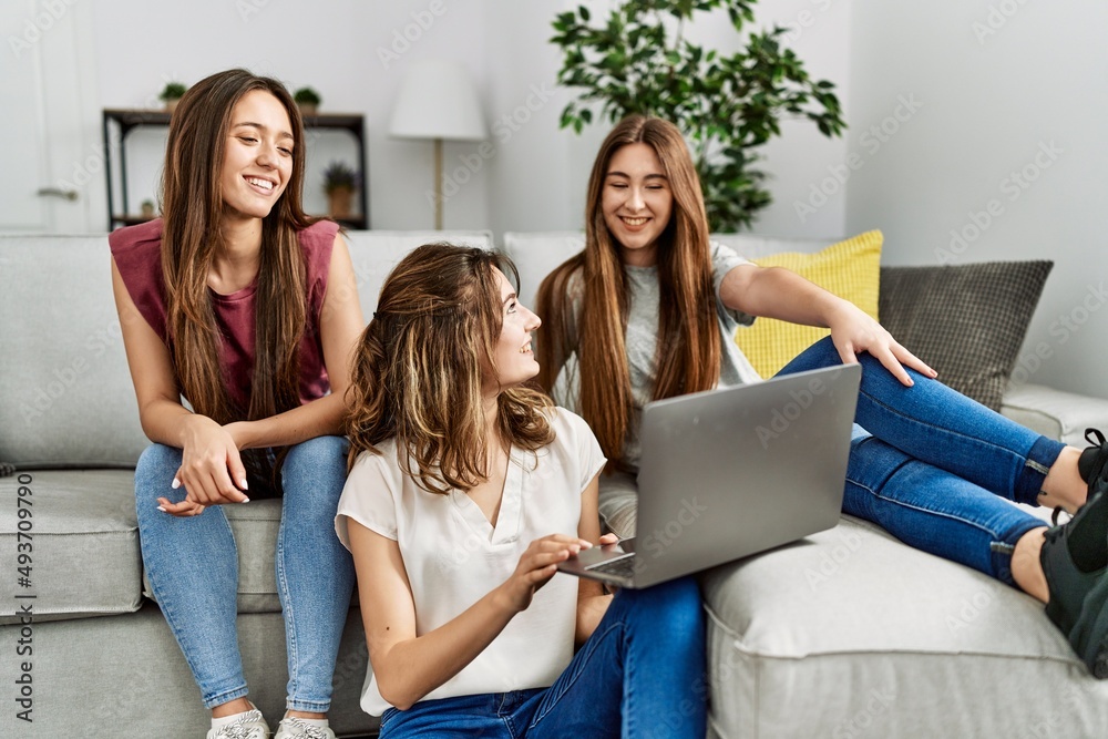 Three young hispanic woman smiling happy using laptop sitting on the sofa at home. Three young hispanic woman smiling happy using laptop sitting on the sofa at home.