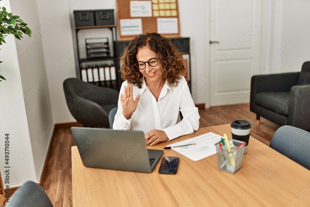 Middle age hispanic woman smiling confident having video call at office Middle age hispanic woman smiling confident having video call at office