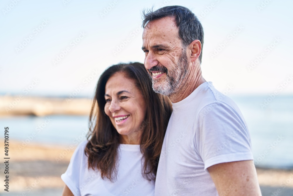 Middle age man and woman couple standing together at seaside Middle age man and woman couple standing together at seaside