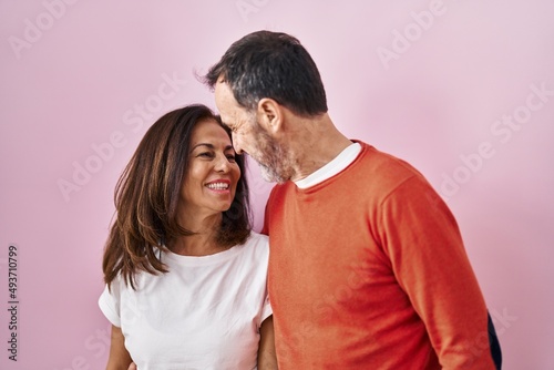 Middle age man and woman couple hugging each other standing over pink background © Krakenimages.com