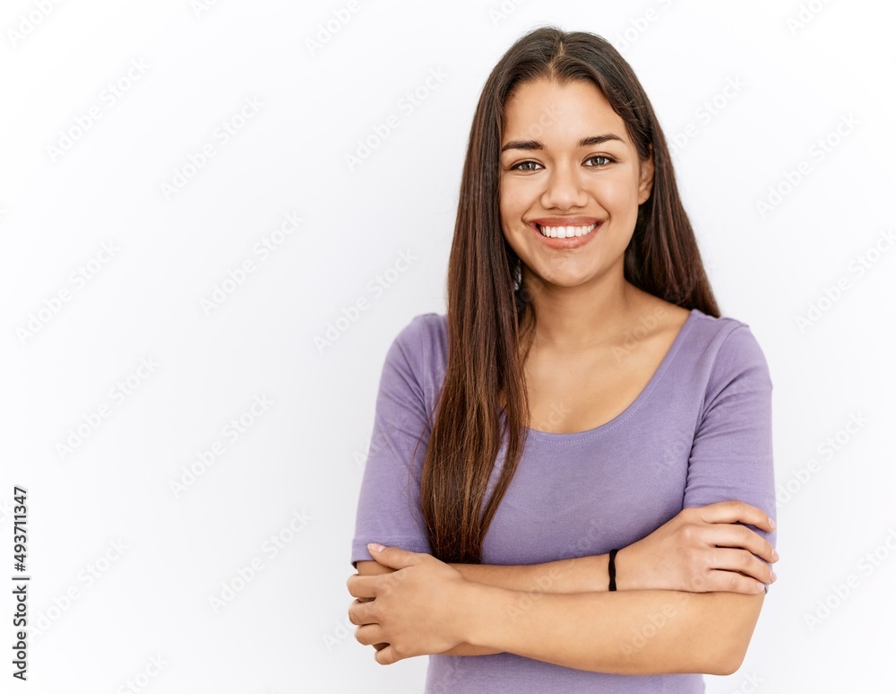 Young brunette woman standing by isolated background happy face smiling with crossed arms looking at the camera. positive person. Young brunette woman standing by isolated background happy face smiling with crossed arms looking at the camera. positive person.