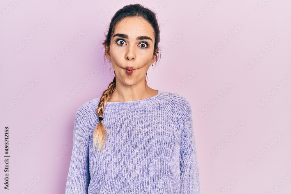 Young hispanic girl wearing casual clothes making fish face with lips, crazy and comical gesture. funny expression. Young hispanic girl wearing casual clothes making fish face with lips, crazy and comical gesture. funny expression.