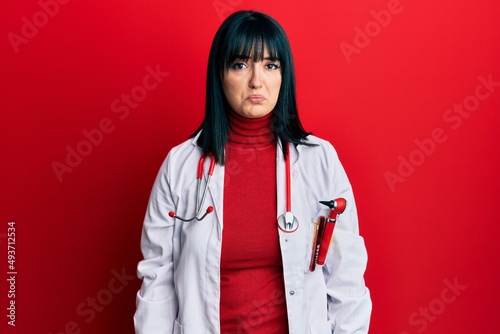 Young hispanic woman wearing doctor uniform and stethoscope depressed and worry for distress  crying angry and afraid. sad expression.
