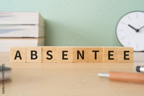 欠席者のイメージ｜「ABSENTEE」と書かれた積み木と本や文房具 photo