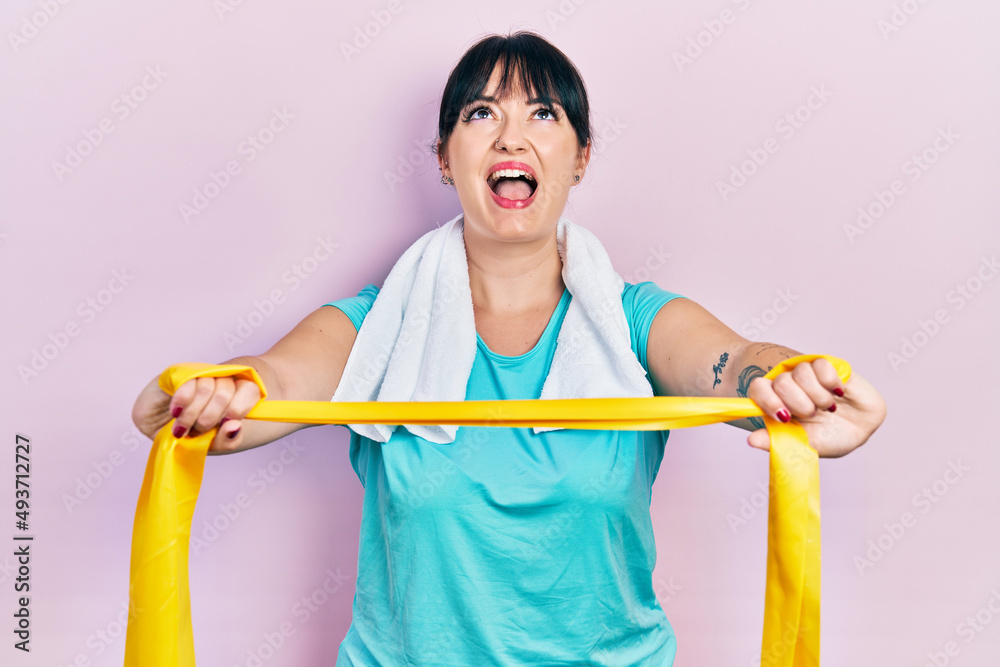 Young hispanic woman wearing sportswear and arm band angry and mad screaming frustrated and furious, shouting with anger looking up. Young hispanic woman wearing sportswear and arm band angry and mad screaming frustrated and furious, shouting with anger looking up.