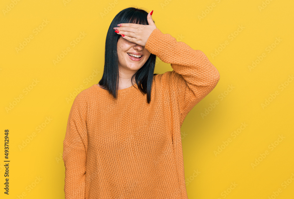Young hispanic woman wearing casual clothes smiling and laughing with hand on face covering eyes for surprise. blind concept.
