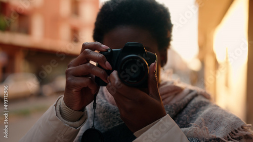 Young african american woman using professional camera at street © Krakenimages.com