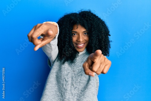 African american woman with afro hair wearing casual winter sweater pointing to you and the camera with fingers  smiling positive and cheerful