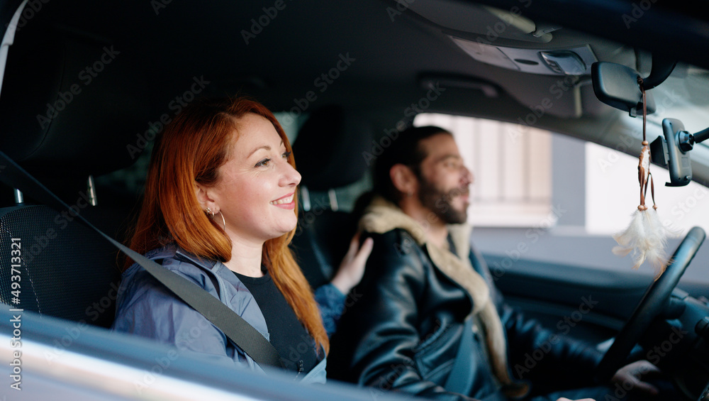 Man and woman couple smiling confident driving car at street