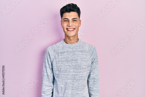Young hispanic man wearing casual clothes with a happy and cool smile on face. lucky person.