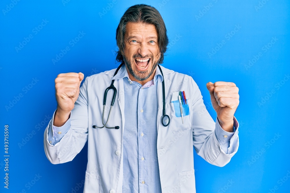 Middle age handsome man wearing doctor uniform and stethoscope celebrating surprised and amazed for success with arms raised and open eyes. winner concept. Middle age handsome man wearing doctor uniform and stethoscope celebrating surprised and amazed for success with arms raised and open eyes. winner concept.