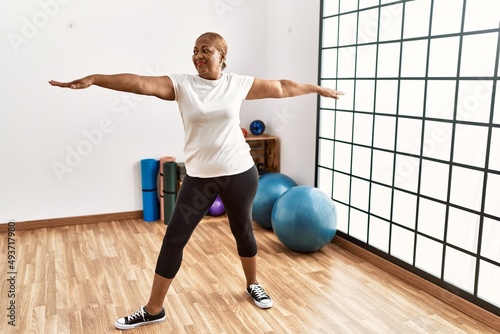 Senior african american woman smiling confident training yoga at sport center photo