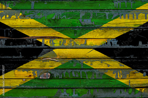 The national flag of Jamaica is painted on uneven boards. Country symbol.