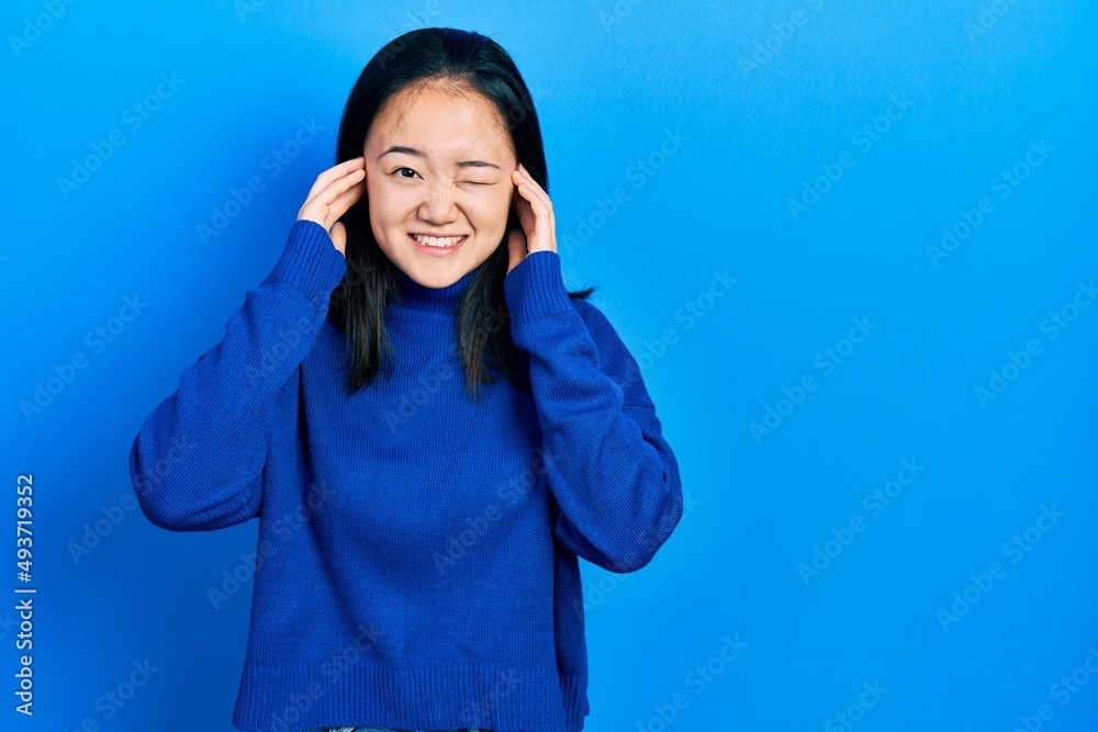 Φωτογραφία Young chinese girl wearing casual clothes covering ears with fingers with annoyed expression for the noise of loud music